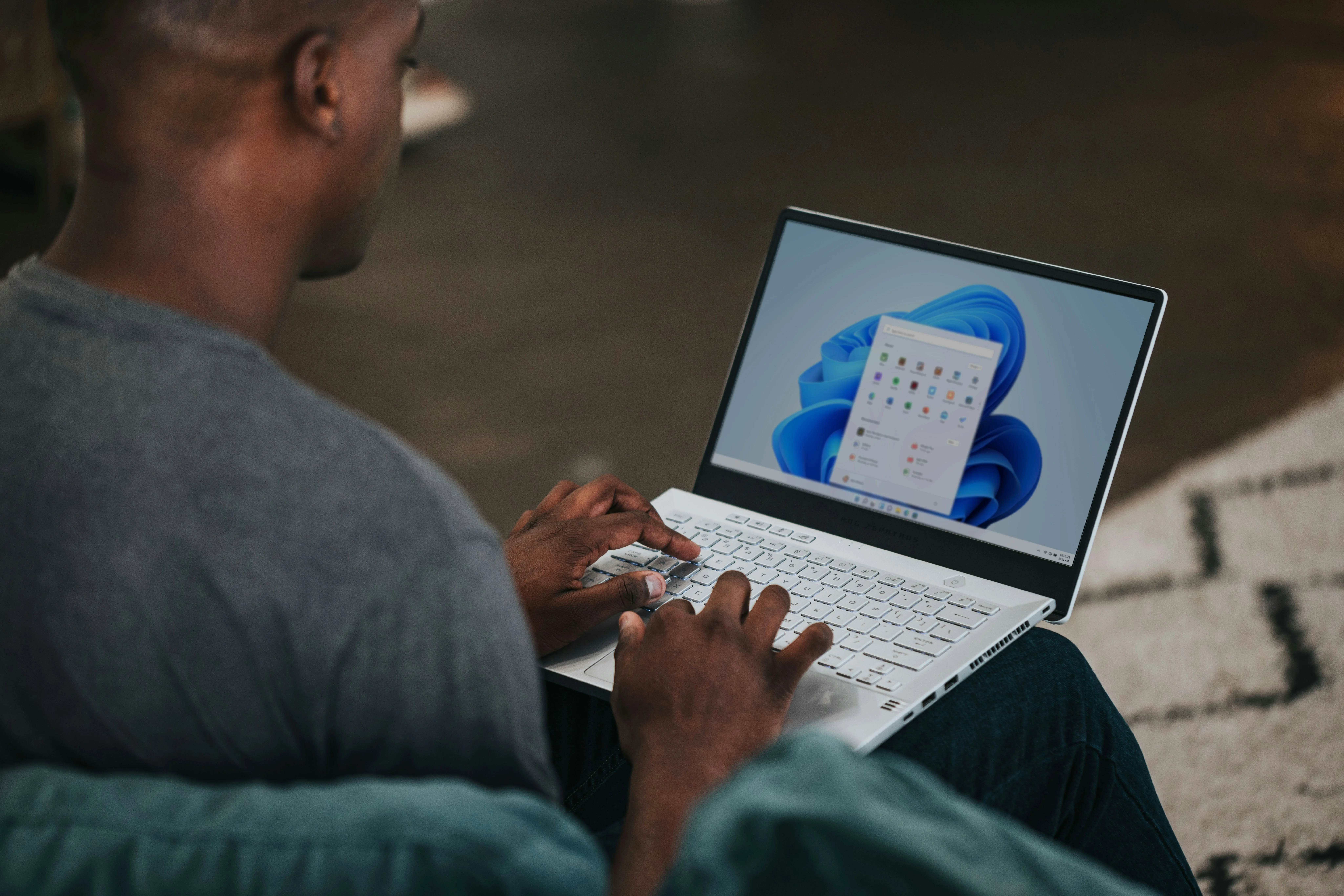 Hombre utilizando un ordenador portátil desde su casa mostrando el escritorio de Windows 11.